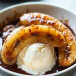 - 4 ripe bananas, sliced lengthwise - 1/2 cup unsalted butter - 1 cup packed brown sugar - 1 teaspoon ground cinnamon - 1/4 teaspoon freshly grated nutmeg - 1/4 cup heavy cream - 1 teaspoon pure vanilla extract - 2 cups creamy vanilla ice cream - For butter, try coconut oil or margarine. - Use almond or oat milk ice cream for non-dairy options. - Replace heavy cream with soy or coconut cream if needed. - Choose bananas that are yellow with a few brown spots. This shows they are ripe. - Fresh spices make a big difference. Always check the expiration date on the bottle. {{ingredient_image_2}} - Melting the butter: Place a large skillet over medium heat. Add 1/2 cup of unsalted butter. Let it melt slowly without letting it brown. - Dissolving the sugar: Once the butter is melted, sprinkle in 1 cup of packed brown sugar. Add 1 teaspoon of ground cinnamon and 1/4 teaspoon of freshly grated nutmeg. Stir it well until the mixture bubbles and the sugar dissolves. - Cooking bananas with the sauce: Carefully place 4 sliced bananas in the skillet, cut side up. Cook for 1-2 minutes until they soften a bit. Then flip them gently with a spatula. Cook for another minute until they caramelize nicely. - Incorporating heavy cream and vanilla: Lower the heat to a gentle simmer. Slowly add 1/4 cup of heavy cream while stirring. Then, pour in 1 teaspoon of pure vanilla extract. Let it cook for another minute to blend the flavors. - Ideal plating techniques: Serve Bananas Foster in deep bowls. Place a big scoop of creamy vanilla ice cream in each bowl. Pour the warm banana sauce over the ice cream generously. - Temperature tips for best flavor: Serve the dish warm. The hot sauce pairs perfectly with the cold ice cream, creating a delightful contrast in temperature and taste. - Overcooking bananas: Cook them just until soft. If they turn mushy, they lose texture. - Using too much or too little sugar: This can affect the sauce's sweetness. Aim for a balanced flavor. - Adding a splash of rum for traditional flair: Rum adds warmth and depth. Use it when you add the cream. - Using different spices or flavorings: Try ginger, cardamom, or even a hint of citrus. These can brighten the dish. - Garnishing ideas: A sprinkle of cinnamon or a mint leaf makes it pop. These little touches impress. - Choosing the right serving dish: Use deep bowls to hold the sauce well. This makes the dish look rich and inviting. Pro Tips Use Ripe Bananas: For the best flavor and texture, make sure your bananas are fully ripe, with a few brown spots on their skin. This sweetness will enhance the dish significantly. Control the Heat: Keep an eye on the heat while cooking. Too high of a temperature can burn the sugar, leading to a bitter flavor. Medium heat is ideal for caramelizing. Experiment with Flavors: Feel free to add a splash of rum or bourbon to the sauce for a traditional twist! This adds depth and complexity to the flavor profile. Presentation Matters: Serve the dish immediately after preparing it. The warm sauce over cold ice cream creates a delightful contrast that enhances the overall experience. {{image_4}} You can switch things up with different fruits. Using plantains gives a unique taste. They add a firmer texture and a mild flavor. Cut them like bananas and follow the same steps. You could also add berries or seasonal fruits. Strawberries, raspberries, or peaches work well. They add a pop of color and freshness. The classic sauce is tasty, but you can change it. Try a chocolate sauce for a sweet twist. Melt chocolate with butter and sugar, then add bananas. For a caramel sauce, use brown sugar and heavy cream. This gives a rich texture that pairs well with bananas. Bananas Foster does not have to stand alone. You can combine it with cakes or crepes. The warm sauce drizzled over a slice of cake is delightful. It also goes well with crepes, adding a fun twist. Pair it with different ice cream flavors, too. Chocolate, coffee, or even mint ice cream can enhance the dish. Each combination offers a new taste adventure. To keep your banana sauce fresh, you should store it in an airtight container. Place the container in the fridge. This helps it stay tasty for about three days. If you find that the sauce thickens, you can add a splash of cream to loosen it up. To reheat the sauce, use a small pot on low heat. Stir gently as it warms up. This keeps the flavors intact. Avoid using high heat, as it can burn the sauce. You can also microwave it in short bursts, stirring in between. This method is quick and easy. You can freeze the banana sauce if you have leftovers. Pour it into a freezer-safe container, leaving space for it to expand. It can last for up to three months in the freezer. When you're ready to use it, move it to the fridge overnight. For faster defrosting, place the container in warm water. Always stir before serving to ensure a smooth texture. Bananas Foster is a classic dessert from New Orleans. It features ripe bananas cooked in a rich sauce. The sauce is made from butter, brown sugar, cinnamon, and rum. This dish first appeared in the 1950s. Chef Paul Blangé created it at Brennan's Restaurant. The dish is named after Richard Foster, a friend of the restaurant owner. Bananas Foster became famous for its dramatic presentation. The sauce is often flambéed for a fun twist. You can prepare some parts of Bananas Foster ahead of time. Slice the bananas and store them in lemon juice to keep them fresh. You can also mix the sugar, cinnamon, and nutmeg in advance. When it’s time to serve, just heat the butter, add the sugar mix, and cook the bananas. This saves time during a party. However, the dish is best served fresh and hot. Yes, Bananas Foster is perfect for a party. It serves four people, making it great for small gatherings. The warm sauce over cold ice cream creates a delightful contrast. For presentation, use deep, elegant bowls. Pour the sauce generously over the ice cream for a stunning look. You can also sprinkle cinnamon or add mint leaves for a nice touch. This dessert is sure to impress your guests! This blog post covered how to make delicious Bananas Foster with ripe bananas and rich butter. We discussed ingredient choices and substitutions for dietary needs. You learned cooking steps, serving tips, and common mistakes to avoid. Variations like chocolate sauce and alternative fruits can elevate the dish. In the end, Bananas Foster is fun to make and easy to love. Enjoy experimenting with flavors and share this tasty treat with friends. You will impress everyone with your skills!