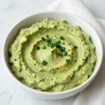 - 2 ripe avocados, halved and pitted - 1 cup sour cream - 1/2 cup mayonnaise - 1/4 cup buttermilk - 1 tablespoon ranch seasoning mix - 1 tablespoon fresh lemon juice - 1 clove garlic, finely minced - Salt and freshly ground pepper - Fresh herbs (chives, parsley) for garnish Gathering the right ingredients is key to making this creamy avocado ranch dip. Start with two ripe avocados. They should feel soft but not too mushy. Next, grab a cup of sour cream. This gives the dip a nice creaminess. You will also need half a cup of mayonnaise. It adds richness that balances the flavors well. Next is buttermilk, a quarter cup for some tanginess. One tablespoon of ranch seasoning mix brings all those good flavors together. Fresh lemon juice is a must, so grab one tablespoon for brightness. Add one clove of finely minced garlic for depth of flavor. Don't forget salt and freshly ground pepper to taste. Finally, fresh herbs like chives and parsley will add a lovely touch on top. Make sure you have everything ready before you start. Each ingredient plays an important role in creating a delicious dip that's perfect for any snack time! {{ingredient_image_2}} Start by cutting the avocados in half. Carefully remove the pits using a spoon. Scoop the green flesh into a mixing bowl. Ripe avocados are key for a creamy dip. In the bowl with the avocado, add the sour cream, mayonnaise, and buttermilk. Each adds a rich, creamy layer. Next, sprinkle in the ranch seasoning mix. Then, squeeze in the fresh lemon juice for a bright taste. Finally, add the finely minced garlic. Use a fork or an immersion blender to mash the mixture together. Blend until smooth and creamy. If you like a chunkier dip, stop blending sooner. The texture can be just how you like it. Once blended, taste your dip. Add salt and freshly cracked pepper to enhance the flavors. Adjust the seasoning as needed. This step is crucial for a balanced dip. Gently fold in some chopped fresh herbs like chives or parsley. This adds a fresh aroma and flavor. Carefully transfer your creamy dip to a serving bowl. Sprinkle extra chopped herbs on top for a nice garnish. Serve with fresh veggies, tortilla chips, or crackers for a colorful spread. Choose ripe avocados for the best dip. Look for avocados that feel slightly soft when you press them. They should not be too mushy or hard. A ripe avocado will have a dark green color. You can also check the stem; if it pops off easily and is green underneath, the avocado is ready. For a creamy dip, mash the avocados until smooth. You can use a fork or an immersion blender. If you like it chunkier, leave some small pieces. The sour cream and buttermilk help make it creamy. Adjust the amount of buttermilk for a thinner or thicker texture. Store any leftover dip in an airtight container. Press plastic wrap directly onto the dip's surface to keep it fresh. This helps prevent browning. Use the dip within two days for the best flavor. You can also mix in a little lemon juice to help keep it green longer. Pro Tips Use ripe avocados: Ensure your avocados are perfectly ripe for a creamy texture. They should yield slightly to gentle pressure when squeezed. Customize the herbs: Feel free to mix and match your favorite fresh herbs, like dill or cilantro, to create a unique flavor profile. Adjust the thickness: If you prefer a thinner dip, gradually add more buttermilk until you reach your desired consistency. Make it ahead: This dip can be made a day ahead and stored in the fridge. Just give it a good stir before serving to refresh its texture. {{image_4}} You can easily change the flavor of your creamy avocado ranch dip. One simple way is to add some diced jalapeños. They give a nice kick and a fresh taste. You might also try adding a teaspoon of smoked paprika. This adds a deep, smoky flavor that pairs well with the creaminess of the dip. For a bit of sweetness, mix in some chopped roasted red peppers. They will brighten the dish, making it even more tasty. If you want a vegan version, you can swap out the dairy. Use coconut yogurt instead of sour cream. It adds creaminess without the dairy. For the mayonnaise, you can use vegan mayo. It keeps the richness while staying plant-based. Buttermilk can be replaced with almond milk mixed with a splash of vinegar. This will give you that tangy flavor. With these swaps, you still get a creamy dip that everyone can enjoy. Feel free to explore other flavors. For a zesty twist, add lime juice instead of lemon juice. This gives a fresh and bright taste. You can also try adding fresh herbs like cilantro or dill. Each herb brings its own unique flavor. If you want something savory, add a dash of Worcestershire sauce. It will deepen the flavor profile. Experimenting with these options can lead to new and exciting dips! To keep your creamy avocado ranch dip fresh, store it in an airtight container. The dip will stay tasty for up to three days in the fridge. If you notice browning on top, just stir it in. The dip will still taste good. Always seal it tight to prevent air from getting in. This helps keep the flavors strong. You can freeze this dip, but the texture may change. If you want to freeze it, use a freezer-safe container. Leave some space at the top for expansion. The dip can last up to two months in the freezer. When you’re ready to eat it, thaw it in the fridge overnight. Stir well before serving to bring back its creamy texture. The creamy avocado ranch dip tastes best fresh, but it can last. In the fridge, expect it to stay good for about three days. If frozen, use it within two months for the best flavor. Always check for any off smells or changes in color before using. Freshness is key to enjoying this dip! To make creamy avocado ranch dip, start by cutting two ripe avocados in half. Remove the pits and scoop the green flesh into a bowl. Next, add one cup of sour cream and half a cup of mayonnaise. Then, pour in a quarter cup of buttermilk for tang. Add one tablespoon of ranch seasoning mix, one tablespoon of fresh lemon juice, and one minced garlic clove. Mash or blend the mix until smooth. If you like it chunkier, blend less. Finally, season with salt and pepper, then fold in some chopped fresh herbs. Yes, you can prepare this dip in advance. Make it up to two days before you plan to serve it. Just keep it in an airtight container in the fridge. The flavors will mix and get even better. Before serving, give it a good stir and taste for seasoning. This dip pairs well with many snacks. You can serve it with fresh vegetables like carrots, cucumbers, and bell peppers. Tortilla chips and crackers are also great choices. You could even spread it on a sandwich for an extra kick of flavor. Get creative and enjoy! This dip can fit into many diets. It contains dairy, so it may not suit those who are lactose intolerant or vegan. However, you can easily modify it by using dairy-free sour cream or yogurt. Check the ranch seasoning mix to ensure it aligns with any dietary needs. To add some heat, mix in spicy ingredients. Try adding diced jalapeños or a few dashes of hot sauce. You could also sprinkle in cayenne pepper or chili powder to taste. Start with a little, then adjust until you reach your preferred spice level. This blog post covered how to make a creamy avocado ranch dip. I shared the ingredients you need and clear, step-by-step instructions. You learned how to prepare avocados, mix the ingredients, and blend for the right texture. I also highlighted tips for selecting avocados and safe storage methods. In the end, this dip is not just tasty but also versatile. Enjoy it as a snack or at your next gathering. You can easily customize it to fit your tastes. Happy dipping!