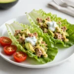 To make Avocado Tuna Salad Lettuce Wraps, you need simple and fresh ingredients. Here’s the list of what you’ll need: - 1 can (5 oz) tuna, drained and flaked - 1 ripe avocado, mashed to a creamy consistency - 1/4 cup Greek yogurt (or mayonnaise for richness) - 1 tablespoon Dijon mustard for a tangy kick - 1 tablespoon fresh lemon juice for brightness - 1 celery stalk, finely chopped for crunch - 1/4 red onion, finely chopped for sweetness - 1 tablespoon fresh dill, chopped (or use 1 teaspoon dried dill) - Salt and fresh ground pepper to taste - 8 large lettuce leaves (Romaine or Butter lettuce work well) - Cherry tomatoes, halved, for garnish These ingredients bring together a mix of flavors and textures. The tuna gives protein, while the avocado adds creaminess. Greek yogurt or mayo can add depth to the flavor. Fresh herbs like dill bring a burst of freshness to each bite. The crunch from celery and onion balances the creaminess. Finally, the lettuce wraps make it light and refreshing, perfect for a healthy meal! {{ingredient_image_2}} 1. Mixing tuna and avocado Start by opening the can of tuna. Drain it well and flake it into a bowl. Then, mash a ripe avocado in the same bowl. Mix the tuna and avocado until they blend into a smooth mixture. 2. Adding Greek yogurt, mustard, and lemon juice Next, add 1/4 cup of Greek yogurt to the bowl. If you want a richer taste, feel free to use mayonnaise instead. Then, add 1 tablespoon of Dijon mustard for some tanginess. Finally, squeeze in 1 tablespoon of fresh lemon juice for brightness. Stir it all together until the mix is creamy and smooth. 3. Incorporating celery, onion, and dill Now, finely chop 1 celery stalk and 1/4 of a red onion. Add them to the bowl along with 1 tablespoon of fresh dill. Gently fold the ingredients together. This adds crunch and sweetness to your salad. Finish by seasoning with salt and pepper to taste. 1. Spoon tuna salad into lettuce leaves Take a large lettuce leaf, like Romaine or Butter lettuce. Spoon a generous amount of the tuna salad mixture right into the center of the leaf. 2. Garnishing with cherry tomatoes Halve some cherry tomatoes and place them on top of the tuna salad. This not only adds color but also a fresh burst of flavor. 3. Folding the lettuce for a wrap Carefully fold the sides of the lettuce leaf over the filling. This creates a neat wrap. Serve your wraps right away for the best taste! To make the best avocado tuna salad, adjust the seasoning to your liking. Start with a pinch of salt and a few grinds of fresh pepper. Taste it after each addition. If you want more zing, add a bit more lemon juice or Dijon mustard. Always remember, the right balance makes a big difference. Choosing the right lettuce type is key. I recommend Romaine or Butter lettuce. Romaine has a nice crunch, while Butter lettuce is tender and wraps beautifully. You can also mix them for a fun texture. Just wash the leaves well and dry them before using. Arranging the wraps on a platter makes them look inviting. Place them side by side, with the open ends facing up. This way, you show off the colorful filling. You can also add extra cherry tomatoes around the wraps for a burst of color. Using additional garnishes can elevate your dish. Fresh dill sprigs on top add a lovely green touch. You can also sprinkle some paprika for a pop of color and extra flavor. These small details make your avocado tuna salad lettuce wraps stand out. Enjoy! Pro Tips Freshness is Key: Use the freshest ingredients possible, especially the avocado and lettuce, to ensure the best flavor and texture in your wraps. Customize Your Protein: Feel free to substitute the tuna with shredded chicken or chickpeas for a different protein option that suits your taste. Herb Variations: Experiment with other herbs like cilantro or parsley if you want to switch up the flavor profile of your tuna salad. Chill Before Serving: For a refreshing experience, let the tuna salad chill in the fridge for 30 minutes before serving to allow the flavors to meld. {{image_4}} You can change the flavor of your tuna salad by switching ingredients. If you want a richer taste, try using mayonnaise instead of Greek yogurt. Mayonnaise adds creaminess that many people love. Just remember, it can be higher in calories. Another way to boost flavor is with herbs or spices. Fresh dill works well, but you could also use parsley or chives. If you like a little heat, add some cayenne pepper or paprika. Experimenting with these options can make your salad unique. Pairing your avocado tuna salad with whole grain crackers adds crunch. This combo is perfect for a snack or light meal. You can also serve it with fresh veggies. Sliced cucumbers or bell peppers are great choices. For a more complete meal, try it alongside a light salad. A simple green salad with lemon vinaigrette balances the richness of the tuna salad. This way, you enjoy a variety of textures and flavors. To keep your avocado tuna salad fresh, store it in an airtight container. This helps prevent air from getting in and making it spoil. Place the container in the fridge right after serving. You can store the tuna salad for up to three days. After that, the flavors may change, and the salad could get watery. Always check for any off smells or textures before eating. You can freeze tuna salad, but it may not taste the same once thawed. The texture of the avocado can change, becoming mushy. If you want to freeze it, scoop the salad into a freezer-safe container. Leave some space at the top for expansion. To thaw, move the container to the fridge overnight. When ready to eat, stir it well before serving. If it seems too watery, you can mix in a bit more Greek yogurt or avocado to improve the texture. You can use several tasty options instead of Greek yogurt. Sour cream works well. It adds creaminess and a slight tang. Silken tofu is another good choice. It blends smoothly and gives a nice texture. Mayonnaise is also a great alternative. It makes the salad richer and creamier. To keep your lettuce wraps crisp, start with fresh leaves. Choose Romaine or Butter lettuce for the best results. Rinse the leaves and dry them well. Avoid cutting the leaves too early. Assemble the wraps just before serving. Keep them in the fridge until ready. This helps prevent wilting and sogginess. Yes, you can make this recipe ahead of time. Prepare the tuna salad and store it in the fridge. You can keep it for up to two days. However, wait to assemble the wraps until just before serving. This keeps the lettuce fresh and crunchy. Enjoy your meal whenever you like! In summary, we covered a tasty tuna salad recipe that combines fresh ingredients and simple steps. You learned how to mix tuna with avocado and Greek yogurt, then assemble tasty lettuce wraps. I shared tips to perfect your salad and make it look great. Lastly, we discussed storage options and even variations to keep things exciting. Enjoy creating your own delicious tuna salad wraps!
