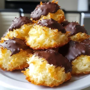 - 2 ½ cups shredded unsweetened coconut - 1 cup sweetened condensed milk - ½ cup dark chocolate chips These main ingredients create a sweet and chewy treat. Shredded coconut gives a great texture. Sweetened condensed milk adds rich sweetness. Dark chocolate adds a delicious contrast. - 1 teaspoon pure vanilla extract - ½ teaspoon almond extract - A pinch of sea salt Vanilla and almond extracts bring warmth and depth. Sea salt balances the sweetness. Just a pinch enhances the overall flavor. - Extra melted chocolate for drizzling Drizzling extra chocolate makes these macaroons even better. It adds a fun look and more chocolate taste. You can skip it or make it fancy! {{ingredient_image_2}} Set your oven to 325°F (163°C). While it heats up, line a baking sheet with parchment paper. This step stops the macaroons from sticking and helps with cleanup. In a large bowl, mix the shredded coconut, sweetened condensed milk, vanilla extract, almond extract, and a pinch of sea salt. Stir these together until they form a sticky and cohesive mixture. The texture should be thick but not dry. Use a small cookie scoop or a tablespoon to make small mounds of the coconut mixture. Place them on the lined baking sheet, leaving space between each mound. Bake in the preheated oven for 15 to 20 minutes. Watch closely for a golden-brown color on top. This means they are ready! To ensure even baking, space the mounds well. This allows hot air to circulate. I recommend leaving about an inch between each mound. This helps them bake evenly. To avoid burnt tops, keep a close eye on your macaroons. Check them around 15 minutes. If they start to brown too quickly, cover them lightly with foil. This can help protect the tops while they finish baking. The best way to melt chocolate is in the microwave. Use a microwave-safe bowl. Heat the chocolate chips in 30-second intervals. Stir after each interval until smooth. If you prefer not to use dark chocolate, try milk or white chocolate instead. They work just as well. You can also use dairy-free chocolate for a vegan option. Let the macaroons cool on the baking sheet for about 10 minutes. This helps them firm up. After 10 minutes, dip the bottoms in melted chocolate. Return them to the parchment paper to set. For the chocolate to harden, refrigerate the macaroons for about 30 minutes. This gives you that perfect chocolate coating. Store them in an airtight container once set. Pro Tips Use Fresh Coconut: For a more intense coconut flavor, try using fresh shredded coconut instead of dried. This will add moisture and freshness to your macaroons. Chill for Better Texture: If you find the mixture too sticky to work with, chill it in the refrigerator for about 15 minutes before shaping. This will make it easier to form mounds. Experiment with Flavors: Feel free to add different extracts or flavorings, such as rum or orange zest, to customize the flavor of your macaroons. Storage Tips: Store the macaroons in an airtight container at room temperature for up to a week or freeze them for longer storage. Just make sure to separate layers with parchment paper. {{image_4}} You can change the flavor of your macaroons easily. Adding a few drops of coconut or lemon extract can give a lovely twist. You can even mix in cocoa powder for a richer chocolate flavor. Just a tablespoon will add a nice depth to your macaroons. If you want vegan options, swap the sweetened condensed milk with coconut cream. This keeps the creamy texture while making it plant-based. For those looking to cut sugar, use a sugar-free sweetened condensed milk. This way, you can enjoy your treat guilt-free. Get creative with toppings! You can sprinkle shredded coconut on top for a fun look. Chopped nuts also add a nice crunch. If you want to impress, try drizzling melted chocolate over the tops. Use a fork to create beautiful patterns. To keep your chocolate coconut macaroons fresh, choose airtight containers. Glass jars or plastic containers work well. Make sure they are sealed tightly to prevent air from getting in. Store the macaroons at room temperature. Keep them away from heat and moisture. A cool, dry place is best for storing. Chocolate coconut macaroons can last about a week when stored properly. After that, they may start to lose flavor. Check for any signs of spoilage. If they smell off or feel hard, it’s best to toss them. Fresh macaroons will feel soft and moist on the inside. Freezing is a great way to save macaroons for later. To freeze, layer them in a freezer-safe container. Place parchment paper between each layer to prevent sticking. They can stay in the freezer for up to three months. When you want to eat them, take them out and let them thaw in the fridge. This keeps their texture nice and chewy. If you want them quicker, you can leave them at room temperature for a few hours. Enjoy your sweet treat anytime! Chocolate coconut macaroons are sweet, chewy treats made with coconut and chocolate. They are small, mound-shaped cookies. The key ingredients include shredded coconut, sweetened condensed milk, and dark chocolate. The macaroons have a crispy outer layer and a soft inside. Their rich, sweet flavor makes them a popular dessert. Yes, you can make macaroons without condensed milk. You can use alternatives like aquafaba or nut butter. These substitutes help bind the coconut without dairy. For a vegan option, try using coconut cream. The texture may differ, but you can still create a delicious treat. You can tell macaroons are done baking by their color. Look for a golden brown top. The edges should also feel firm to the touch. If they are still soft, give them a few more minutes. Let them cool slightly to check their texture before serving. In this post, we explored how to make delicious chocolate coconut macaroons. We looked at key ingredients, step-by-step instructions, and tips for baking. Variations let you customize these treats, catering to different diets. Storage advice keeps your macaroons fresh for longer. Whether you choose to drizzle extra chocolate or mix in new flavors, your macaroons will impress. Enjoy the process and the tasty results. Now, you’re ready to create your own batch!