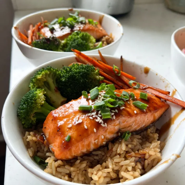 - 2 salmon fillets (approximately 6 oz each) - 1 cup jasmine rice - 1 cup water or vegetable broth - 1 tablespoon sesame oil - 1/4 cup low-sodium soy sauce - 2 tablespoons honey or maple syrup - 1 tablespoon rice vinegar - 1 teaspoon fresh ginger, grated - 1 clove garlic, minced - 1 cup broccoli florets - 1 medium carrot, julienned - 2 green onions, finely chopped - Sesame seeds (for garnish) - Salt and freshly ground black pepper (to taste) - Additional sesame seeds - Extra chopped green onions - Edible flowers for decoration This dish is rich in protein from salmon and fiber from vegetables. A serving provides: - Calories: 480 - Protein: 35g - Carbohydrates: 45g - Fat: 18g - Fiber: 4g - Sugar: 10g Eating this meal gives you a balanced mix of nutrients. The salmon offers omega-3 fatty acids, which are great for heart health. The vegetables add vitamins and minerals to your diet. Enjoy this tasty and healthy dish! {{ingredient_image_2}} First, rinse 1 cup of jasmine rice under cold water. Keep rinsing until the water runs clear. This step removes extra starch. In a medium pot, combine the rinsed rice with 1 cup of water or vegetable broth. Bring it to a boil over high heat. Once it boils, lower the heat, cover the pot, and let it simmer for about 15 minutes. After the time is up, check if the liquid is absorbed. Fluff the rice with a fork and keep it warm. Grab a small bowl and add 1/4 cup of low-sodium soy sauce. Then, add 2 tablespoons of honey or maple syrup, 1 tablespoon of rice vinegar, 1 teaspoon of grated ginger, and 1 minced garlic clove. Whisk all these together until the mixture is smooth and the honey dissolves. This sauce will give your salmon a sweet and salty kick. Heat 1 tablespoon of sesame oil in a non-stick skillet over medium heat. Season 2 salmon fillets with salt and pepper. Place the salmon skin-side down in the skillet. Let it cook for about 4-5 minutes until the skin is crispy. Gently flip the salmon and brush a good amount of teriyaki sauce on top. Cook for another 3-4 minutes until it’s just right for you. In the same skillet, toss in 1 cup of broccoli florets and 1 julienned carrot. Sauté them for 2-3 minutes. Stir often until they look bright and tender but still crunchy. For extra flavor, drizzle a bit of teriyaki sauce over the veggies. Grab your bowls and add a scoop of jasmine rice to each one. Arrange the sautéed vegetables next to or on top of the rice. Then, place the teriyaki salmon fillet on top. Drizzle more teriyaki sauce over the salmon for added taste. Before serving, sprinkle chopped green onions and sesame seeds on each bowl. This adds a nice touch and makes it look great. Enjoy your meal! To cook salmon just right, you need control over the heat. Start by heating the skillet over medium heat. This helps the salmon cook evenly. Season the fillets with salt and pepper. Place them skin-side down in the pan. This will give you a nice crispy skin. Cook for 4-5 minutes before flipping. Brush on the teriyaki sauce and cook for another 3-4 minutes. Check for doneness by gently pressing the fillet. It should flake easily but still be moist. You can boost the flavor of your teriyaki salmon bowls with simple additions. Try adding a splash of lime juice for a fresh twist. You can also top the bowls with avocado slices for creaminess. For a spicy kick, add sliced jalapeños or a drizzle of sriracha. If you love more crunch, sprinkle some crushed peanuts on top. These small changes can make a big difference. Meal prep makes cooking easier during busy weeks. You can cook the rice and salmon in advance. Store them in separate containers in the fridge. Prepare the teriyaki sauce ahead of time as well. It lasts about a week in the fridge. When you’re ready to eat, just reheat and assemble your bowls. This way, you enjoy a healthy meal without spending too much time in the kitchen. Pro Tips Perfecting the Rice: To achieve fluffy jasmine rice, ensure to rinse it thoroughly to remove excess starch. This prevents it from becoming sticky during cooking. Flavor Infusion: For an extra depth of flavor in your salmon, marinate it in the teriyaki sauce for 30 minutes before cooking. This will enhance the taste significantly. Vegetable Crunch: When blanching vegetables, aim for a vibrant color and slight crunch. This not only enhances the presentation but also maintains their nutritional value. Garnish with Style: Elevate the visual appeal of your dish by garnishing with toasted sesame seeds and finely chopped green onions. A sprinkle of sesame oil just before serving can also add a delightful aroma. {{image_4}} You can change the veggies in your teriyaki salmon rice bowls. Broccoli and carrots are great, but try snap peas, bell peppers, or zucchini. Each option gives a new taste and texture. For a crunch, add some water chestnuts or sliced radishes. Just remember, keep the cooking time short so they stay crisp. The teriyaki sauce is tasty, but you can explore other marinades too. Try a miso glaze for a rich flavor. A honey-soy blend adds sweetness. For a spicy kick, mix in some sriracha or chili paste. You can even use a citrus marinade with orange or lemon juice for a bright twist. The choice is yours! If you want a different base, there are many options. Quinoa is a healthy choice with a nice bite. Cauliflower rice works if you're looking for a low-carb option. Brown rice adds a nutty flavor and more fiber. You can also use noodles like soba or rice noodles for a fun twist. Each option gives a unique taste to your bowl. To store leftovers, let the food cool first. Place the salmon, rice, and veggies in separate airtight containers. This keeps everything fresh and tasty. Store them in the fridge for up to 3 days. If you mix them, the rice can get mushy. Keeping them separate keeps the flavors intact. When reheating, use the microwave for quick meals. Place the salmon and veggies in a bowl. Cover it with a damp paper towel to retain moisture. Heat on medium power for 1 to 2 minutes. Stir halfway through to ensure even heating. The salmon should be warm but not overcooked. For the rice, add a splash of water before reheating. This helps it steam back to life. You can freeze the teriyaki salmon rice bowls. First, cool everything completely. Then, pack the salmon, rice, and veggies in freezer-safe bags. Remove as much air as possible to prevent freezer burn. They can last in the freezer for up to 2 months. To eat, thaw overnight in the fridge. Reheat as directed above for a quick meal. You can use basmati rice or short-grain rice. Both have a nice texture. Brown rice is another good choice, but it takes longer to cook. Remember, the flavor will change slightly with each type. Yes, using frozen salmon is fine. Just thaw it completely before cooking. This helps it cook evenly. You can thaw salmon overnight in the fridge or use cold water for a quicker method. Homemade teriyaki sauce lasts about a week in the fridge. Store it in an airtight container. If you want it to last longer, you can freeze it. Just thaw when you need it. This recipe is not gluten-free due to the soy sauce. You can use gluten-free soy sauce or tamari. This makes it safe for those with gluten allergies. This blog post covered how to make a delicious teriyaki salmon bowl. We discussed the main ingredients like salmon and jasmine rice, as well as optional garnishes. The step-by-step guide showed how to prepare everything properly. You learned useful tips for the best flavor and meal prep. For those wanting variety, we explored different vegetables and marinades. Lastly, we shared how to store and reheat leftovers. Enjoy this meal anytime with these simple steps. Happy cooking!