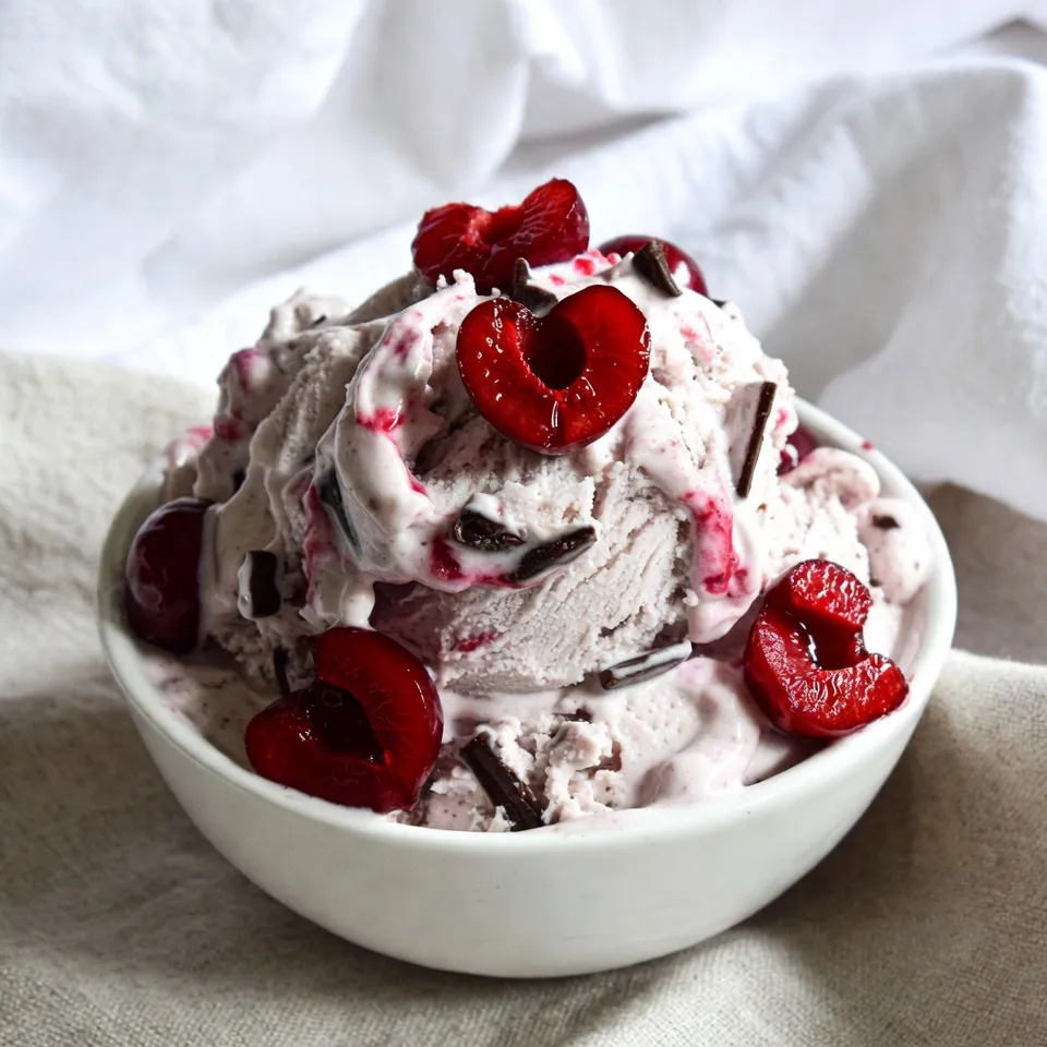 - 2 cups fresh or frozen cherries, pitted and halved - 1 cup heavy cream - 1 cup whole milk - ¾ cup granulated sugar, divided - 1 teaspoon vanilla extract - ½ cup dark chocolate chunks - ¼ teaspoon salt - 1 tablespoon lemon juice When measuring the cherries, make sure they are pitted. This helps avoid any surprises while eating. Use a liquid measuring cup for the cream and milk to get an accurate amount. For sugar, use dry measuring cups to ensure the right sweet balance. Use ripe, sweet cherries for the best flavor. Check for firmness and vibrant color. If you choose frozen cherries, pick a brand with no added sugar. For cream and milk, choose full-fat options. This gives your ice cream a rich, creamy texture. Dark chocolate chunks should be high quality, with at least 60% cocoa content. This adds depth to your ice cream. {{ingredient_image_2}} First, take your fresh or frozen cherries. Pitting and halving them makes them easier to cook. In a medium saucepan, add the cherries, 2 tablespoons of granulated sugar, and lemon juice. Heat this over medium heat. Stir the mixture gently for about 5 to 7 minutes. You want the cherries to soften and release their juices. Once they look shiny and juicy, remove the pan from heat and set it aside to cool. While your cherry mixture cools, grab a large mixing bowl. In this bowl, add the heavy cream, whole milk, the remaining ½ cup of sugar, vanilla extract, and salt. Use a whisk to mix everything together. Keep whisking until the sugar dissolves completely. The mixture should become smooth and creamy. This base is what will make your ice cream rich and tasty. Now it’s time to combine the mixtures. Carefully fold the cooled cherry mixture into the cream mixture. Make sure to save a few cherry halves for later. Stir gently, but don’t overmix. You want to see swirls of cherry in your cream. Next, pour this combined mixture into your ice cream maker. Churn it according to the manufacturer's instructions for about 20 to 25 minutes. You want it to reach a soft-serve texture. In the last few minutes, add the dark chocolate chunks. This step spreads the chocolate throughout the ice cream. Once done, transfer the ice cream into an airtight container. To keep it fresh, press plastic wrap against the top. This will help prevent ice crystals. Seal the container with its lid and freeze for at least 4 hours. This will make it firm enough for scooping. Enjoy your homemade cherry chocolate chunk ice cream! To get that rich and creamy texture, use heavy cream and whole milk. These ingredients keep the ice cream smooth. Make sure to whisk the cream and sugar until fully mixed. This step is key for a velvety base. Churning the mixture in your ice cream maker is also important. It incorporates air, which makes the ice cream light and fluffy. Ice crystals can ruin your ice cream's texture. To avoid this, press plastic wrap against the surface of the ice cream before sealing it. This keeps air out and helps maintain a smooth texture. Also, try to store the ice cream in an airtight container. This way, it won't absorb other flavors from the freezer. For a fun serving idea, use chilled bowls. This keeps the ice cream from melting too quickly. Top each bowl with reserved cherry halves and extra chocolate chunks. This adds a nice touch and makes it look fancy. You can also pair your ice cream with a warm dessert, like brownies or pie. The contrast of warm and cold is a treat! Pro Tips Choose the Right Cherries: Opt for ripe, sweet cherries for the best flavor. If using frozen cherries, ensure they're unsweetened to keep control of the sugar levels. Chill Your Mixture: For a creamier texture, refrigerate the ice cream base for at least an hour before churning. This helps the mixture churn more efficiently. Use Good Quality Chocolate: Invest in high-quality dark chocolate chunks. They will melt beautifully and enhance the overall taste of your ice cream. Experiment with Add-ins: Feel free to add other mix-ins such as nuts or different fruits in the last few minutes of churning for added texture and flavor. {{image_4}} You can swap cherries for other fruits. Try strawberries, blueberries, or raspberries. These fruits add bright flavors. Each fruit brings its own sweet touch. Mix and match for fun combinations. For example, use peaches for a summer vibe. You can even mix fruits together for a unique twist. Want a dairy-free treat? Use coconut milk instead of cream and milk. Almond milk works well too. Replace sugar with maple syrup or agave. For a creamy texture, add soaked cashews blended smooth. This way, you keep the sweet, rich taste. Your vegan friends will love this choice! Dark chocolate is a classic choice for this ice cream. But you can also use milk chocolate for a sweeter flavor. White chocolate adds a creamy touch with a hint of sweetness. For a fun twist, try adding chocolate-covered cherries. This gives a double dose of chocolate delight. Mix different chocolates to suit your taste. To keep your cherry chocolate chunk ice cream fresh, use an airtight container. This prevents air from getting in and keeps your ice cream creamy. Press plastic wrap against the surface before sealing it. This step stops ice crystals from forming, which can ruin the texture. After you churn the ice cream, freeze it for at least 4 hours. This allows it to harden properly. If you want to enjoy it later, leave it in the freezer until you are ready to serve. Just remember, the longer it sits, the firmer it gets. Homemade ice cream lasts about 2 to 3 weeks in the freezer. After that, it may lose flavor and texture. To make the most of your ice cream, enjoy it sooner rather than later. If you notice ice crystals or freezer burn, it’s best to toss it out for a fresh batch! Yes, you can use frozen cherries. They work well and save time. Just thaw them before cooking. This helps them release their juices. You’ll enjoy that fruity flavor just like fresh cherries. You can store homemade ice cream for about two weeks. Keep it in an airtight container. This keeps it fresh and tasty. After two weeks, the flavor might fade a bit. If it lasts longer, check for ice crystals. No ice cream maker? No problem! You can still make this treat. After mixing all your ingredients, pour them into a shallow dish. Freeze it for about 30 minutes. Stir every 30 minutes until it gets creamy. This method takes more time but gives you a delicious result. This blog post covered all the key steps to make tasty cherry ice cream. We discussed the right ingredients, how to mix and freeze them, and tips for a creamy treat. I shared variations and storage tips to help you enjoy it longer. Remember, using quality ingredients makes a big difference. With these steps and tips, you can create a delicious dessert that everyone will love. Go ahead and make your cherry ice cream; it’s easier than you think! Enjoy your sweet creation!